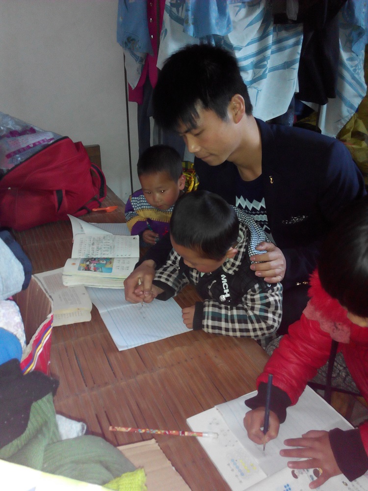 2室內(nèi)設計班溫朋在輔導小孩做作業(yè)并教他們畫畫.jpg